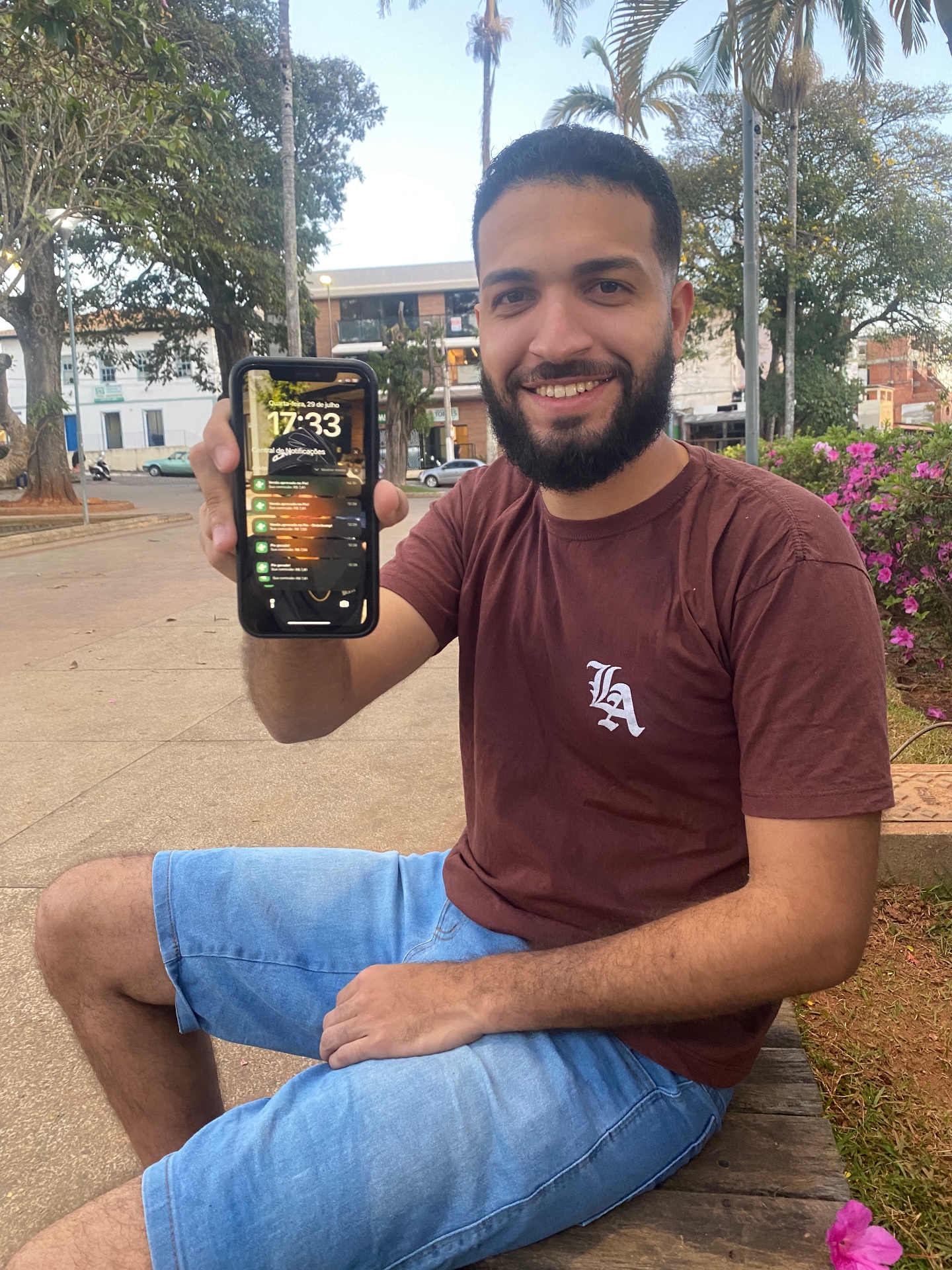 Warley Pinheiro segurando o celular com notificações de vendas